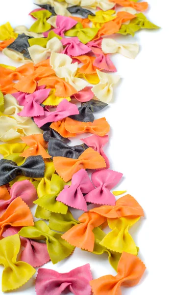 Colored farfalle pasta, on the left edge — Stock Photo, Image