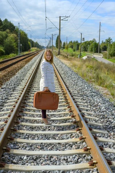 Ung flicka med resväska på järnvägar — Stockfoto