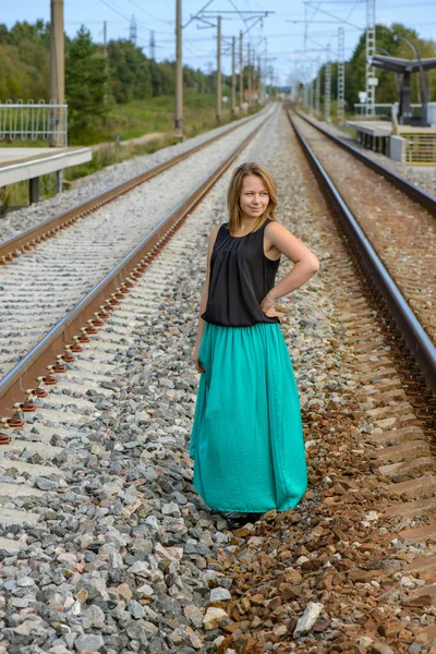 Chica de pie entre dos vías férreas — Foto de Stock