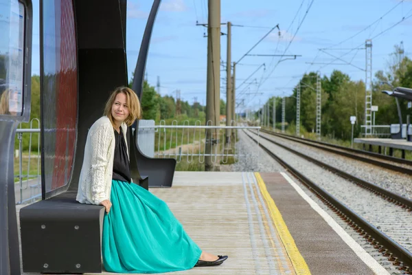 Menina sentada na estação ferroviária — Fotografia de Stock