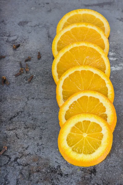 Fatias de laranja dispostas em um fundo escuro — Fotografia de Stock