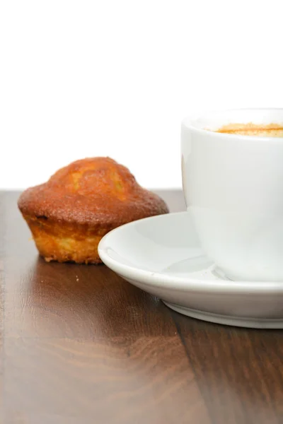 Halbe Tasse Kaffee mit Cupcake auf dem Tisch — Stockfoto