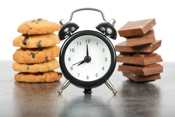 Black alarm clock and sweets — Stock Photo, Image