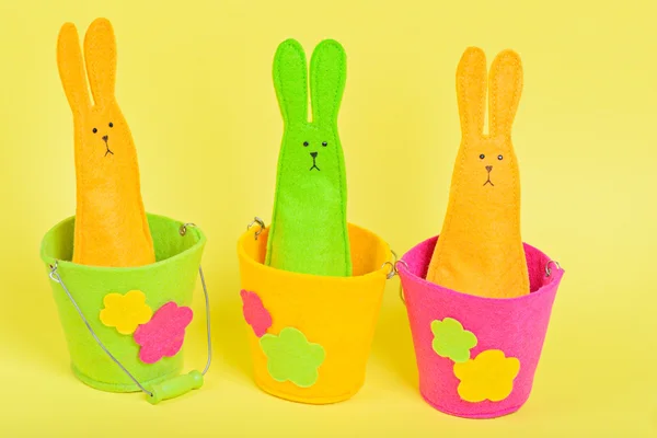 Three easter Bunnies in buckets on yellow — Stock Photo, Image