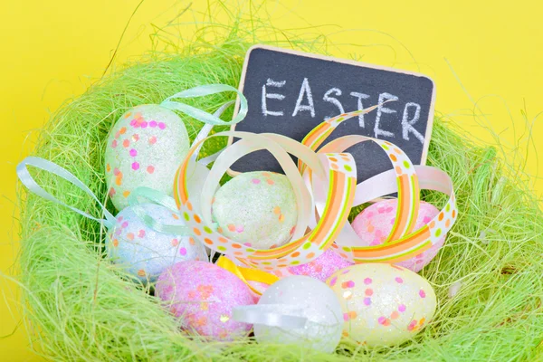 Ester eggs in nest with copy-space blackboard — Stock Photo, Image