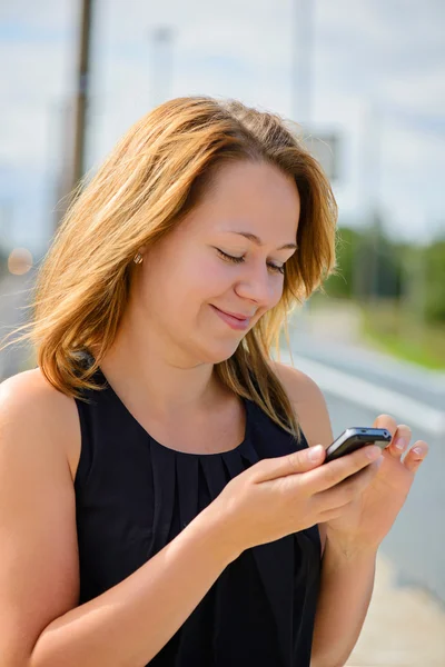 Unga glada vackra kvinna med mobiltelefon — Stockfoto