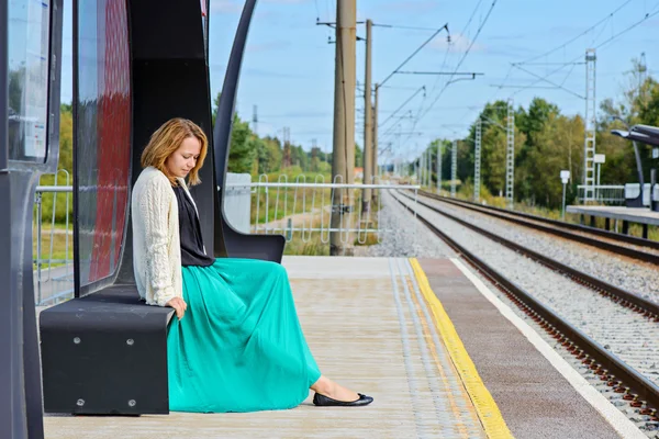 Feminino sentado e esperando trem na plataforma — Fotografia de Stock