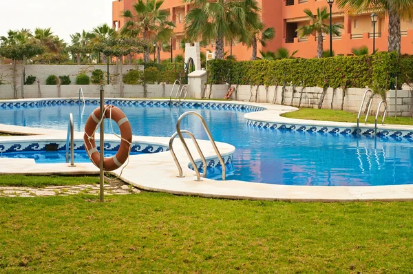 Blue swimming pool and orange lifebelt — Stock Photo, Image