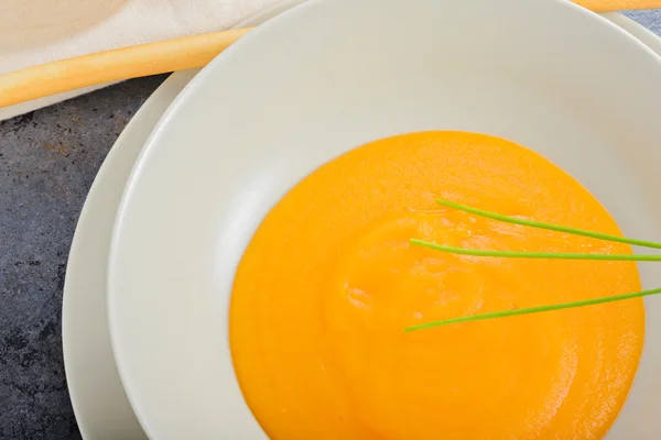 Помаранчевий гарбузовий вершковий суп та зелена цибуля — стокове фото
