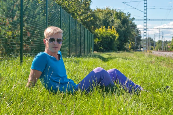 Jeune homme élégant couché sur l'herbe verte — Photo