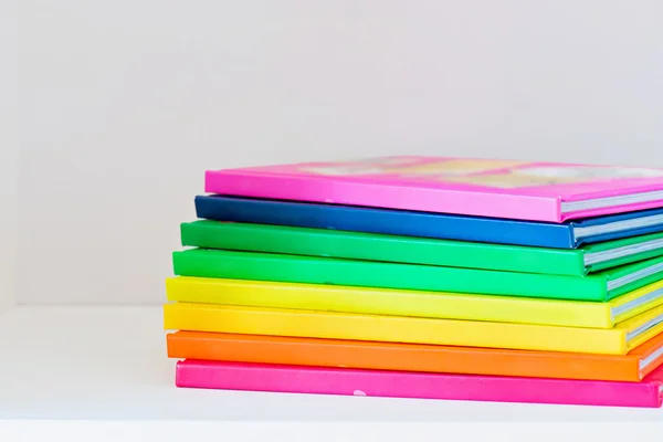 Multi colored books in stack on the light-coloured bookshelf — Stock Photo, Image