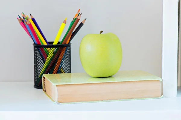 A yellow apple sitting on top of book — Stock Photo, Image