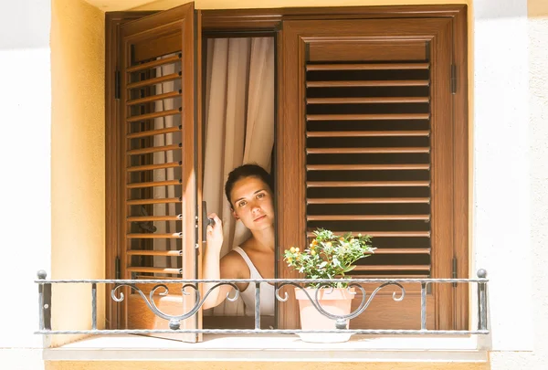 Ragazza guarda fuori dalla finestra di una casa di campagna — Foto Stock