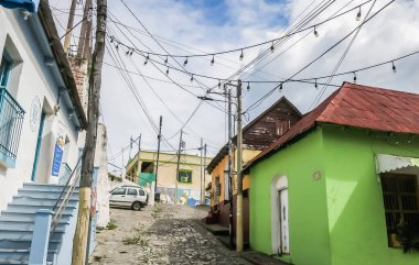 Şehrin eski kısmı, dar kaldırımlı caddeler, kırmızı çatılı binalar ve pastel evlerle koloni tarzında. Guatemala. Flores, El Peten.