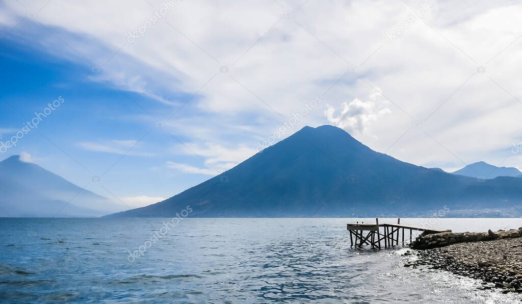 Wooden pier at Lake Atitlan on the beach in Panajachel, Guatemala. With beautiful landscape scenery of volcanoes Toliman, Atitlan and San Pedro 