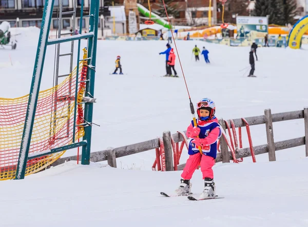 Un piccolo sciatore indefinito con tuta da sci nello skilift — Foto Stock