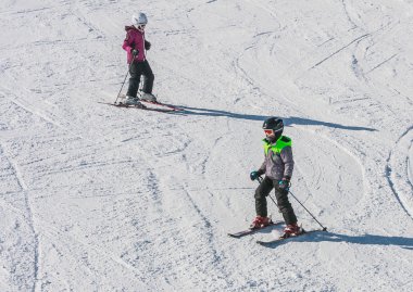 LIVIGNO, ITALY - JANUARY 28, 2015: Young skiers on the slope of  Ski resort Livigno, Lombardi, January 28, 2015, Italy. Livigno is  developing ski resort in northern Italy
