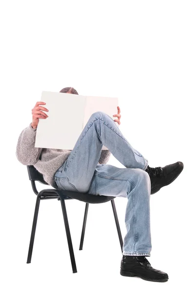 Man in een stoel met een magazine — Stockfoto