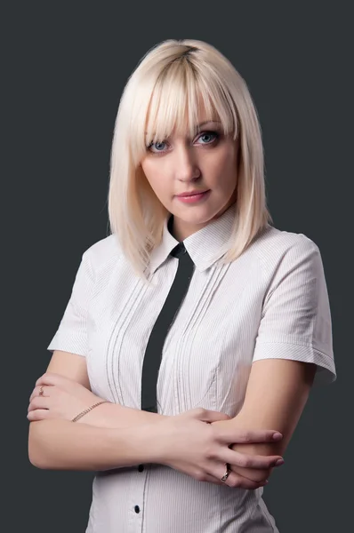 Business woman looking at the camera with crossed arms on a gray — Stock Photo, Image