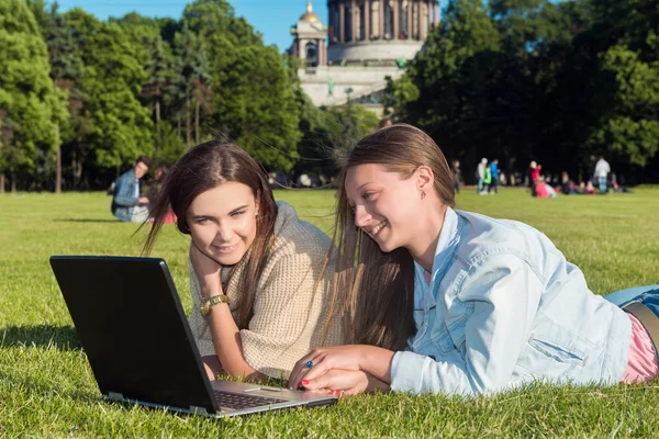 Dos chicas en el parque con un portátil — Foto de Stock