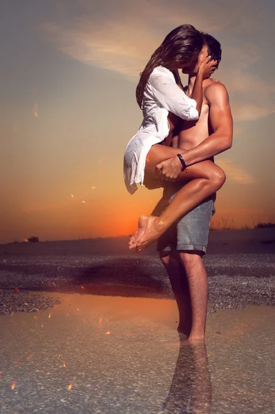 Par på stranden vid solnedgången — Stockfoto