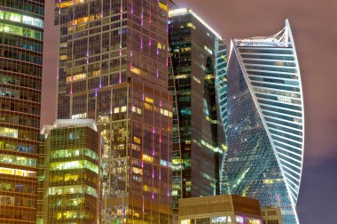 Şehrin iş bölgesinde renkli gece lambaları var. Büyük bir şehrin gece yarısı ışıkları nehire yansıyor.