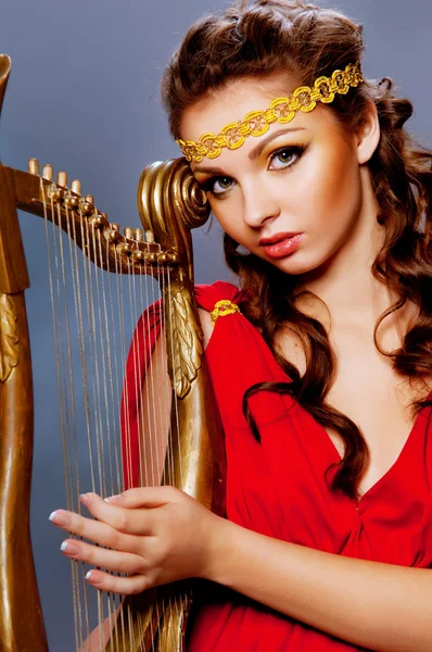 Beautiful young girl playing the harp — Stock Photo, Image