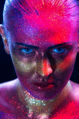 Siyah arka planda güzel bir kadının yüzünde ışıltılı bir makyaj.