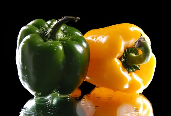 Grüne und gelbe Paprika auf schwarzem Hintergrund — Stockfoto