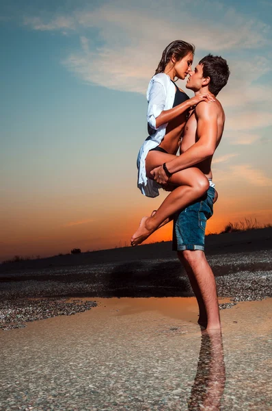 Coppia sulla spiaggia al tramonto — Foto Stock