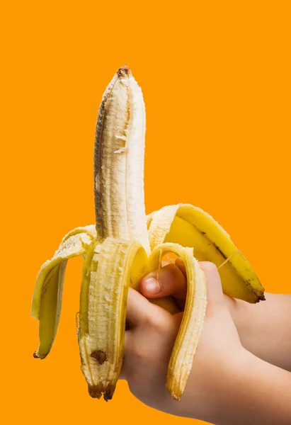 Banaan in hand geïsoleerd op oranje achtergrond — Stockfoto