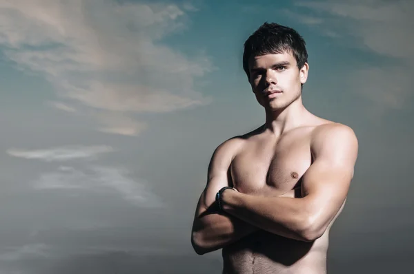 Schöner gut aussehender Mann am Strand, der nach dem Schwimmen glücklich lächelt — Stockfoto