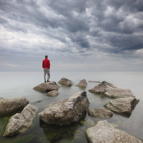 Homem a olhar para o mar . Fotos De Bancos De Imagens