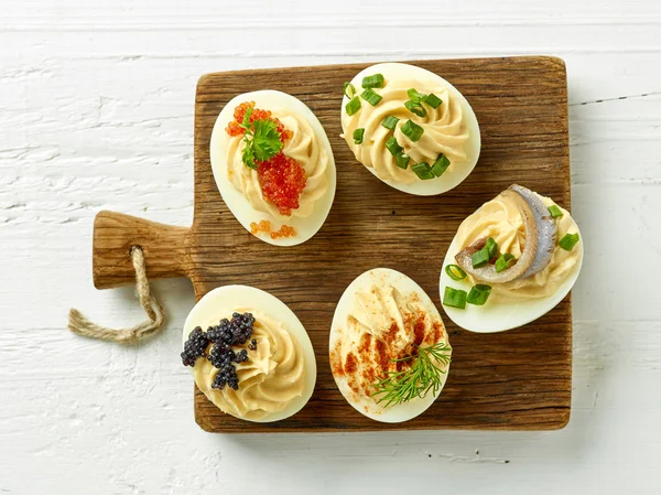 Gekookte decoratieve eieren op houten snijplank — Stockfoto