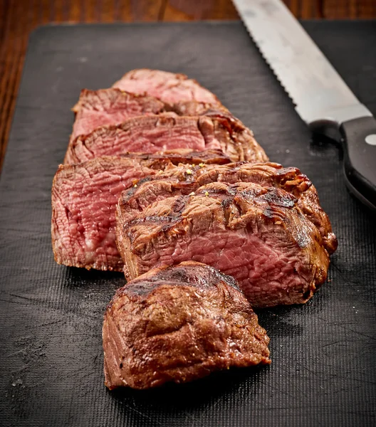 Grilled sliced beef steak and knife — Stock Photo, Image