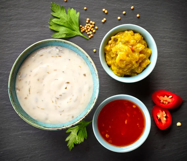 Various sauces on black background — Stock Photo, Image