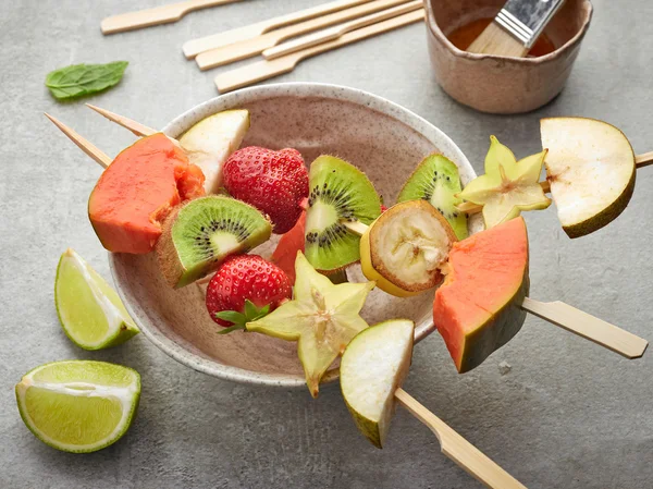 Bagas frescas e pedaços de frutas em espetos — Fotografia de Stock