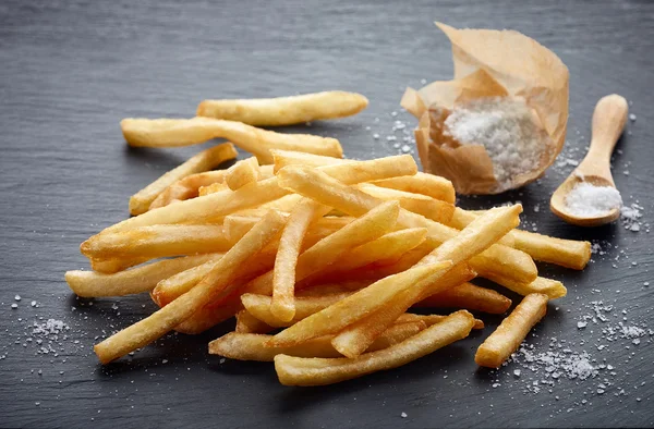 Patatine fritte su sfondo di pietra nera — Foto Stock