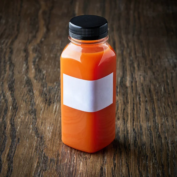 木桌上的新鲜胡萝卜汁瓶子 — 图库照片