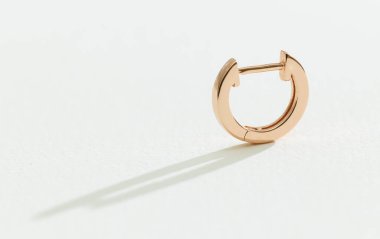 Beyaz bir arka planda altın küpe 