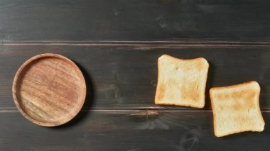 Koyu ahşap mutfak masasında çikolata kremalı kızarmış ekmek dilimleri, üst manzara. dur hareket animasyonu, sağlıklı kahvaltı konsepti