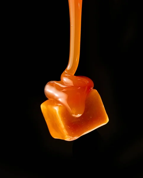 Karamelsaus Stromend Vliegende Karamel Snoep Geïsoleerd Zwarte Achtergrond — Stockfoto