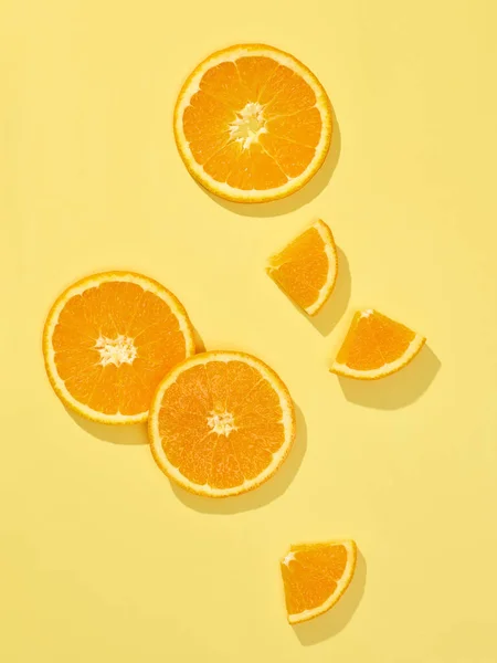 黄色の背景に隔離された新鮮なオレンジ色のスライス構成トップビュー — ストック写真