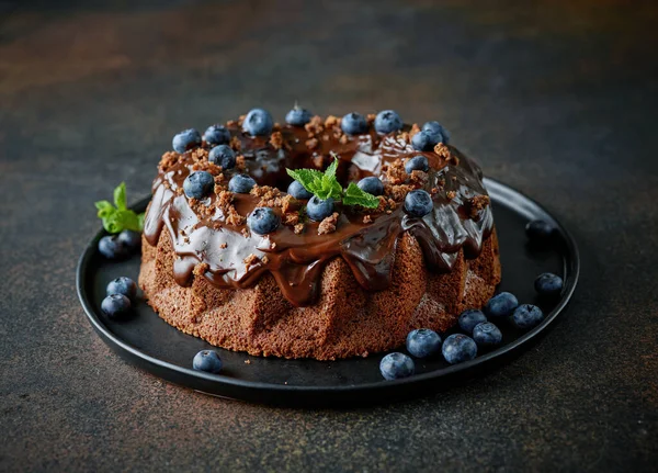 Свіжоспечений Шоколадний Торт Прикрашений Розтопленим Шоколадом Свіжою Чорницею Чорній Тарілці — стокове фото