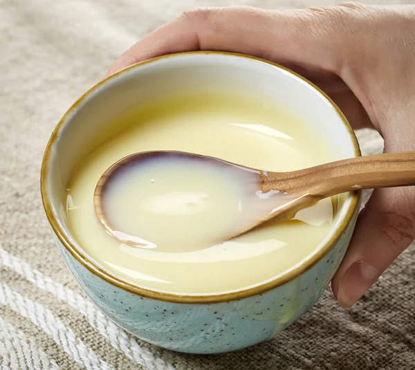 Skål med kondenserad mjölk med socker — Stockfoto