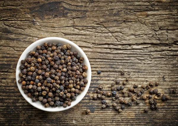 Bowl of black pepper corns — Stock Photo, Image