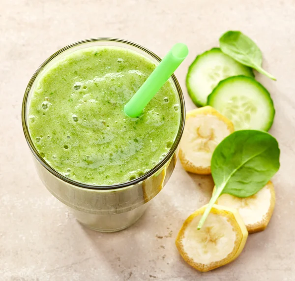 Glass of banana, spinach and cucumber smoothie with a straw — Stock Photo, Image