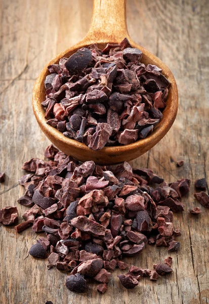 Spoon of crushed cocoa beans — Stock Photo, Image