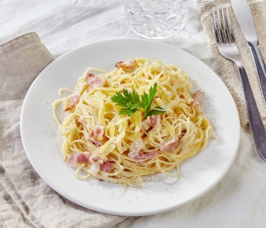 Makarna Carbonara beyaz plaka üzerinde