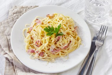 Makarna Carbonara beyaz plaka üzerinde